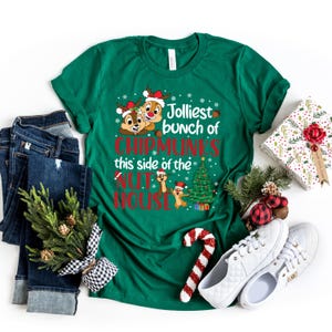 May include: Green t-shirt with a Christmas-themed design featuring cartoon chipmunks wearing Santa hats and the text "Jolliest bunch of Chipmunks this side of the Nut House".
