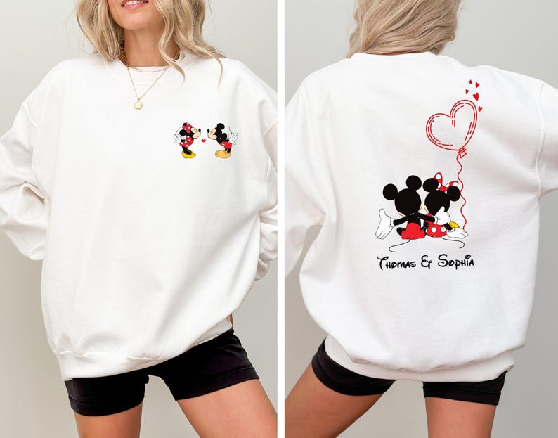 May include: White sweatshirt with a Mickey Mouse and Minnie Mouse graphic on the front and a Mickey Mouse and Minnie Mouse graphic with a heart balloon and the text "Thomas & Sophia" on the back.