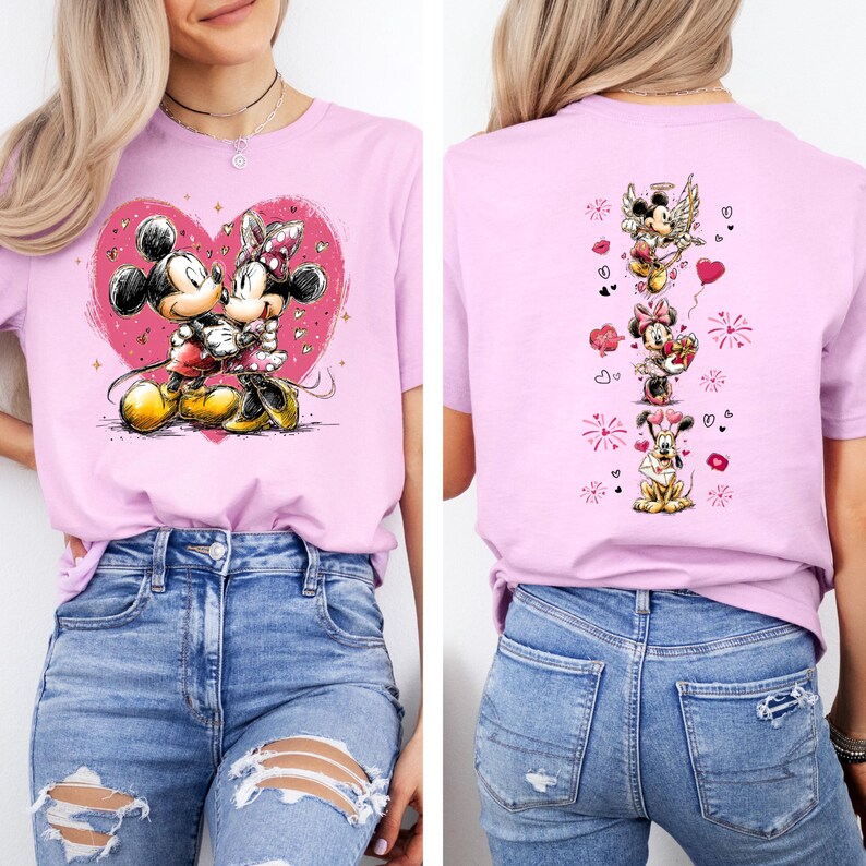 May include: A light pink t-shirt featuring Mickey and Minnie Mouse embracing within a pink heart. The back of the shirt displays several cartoon images of Mickey and Minnie Mouse with hearts and angel wings.