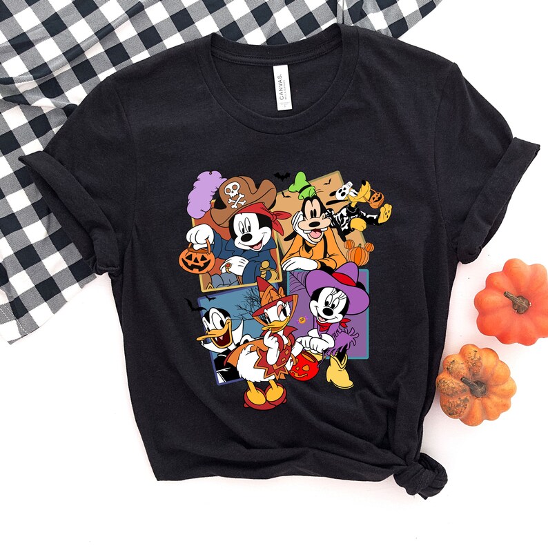 May include: Black t-shirt with a colorful graphic of Mickey Mouse, Minnie Mouse, Donald Duck, Goofy, and Pluto dressed in Halloween costumes. The characters are holding candy buckets and pumpkins.