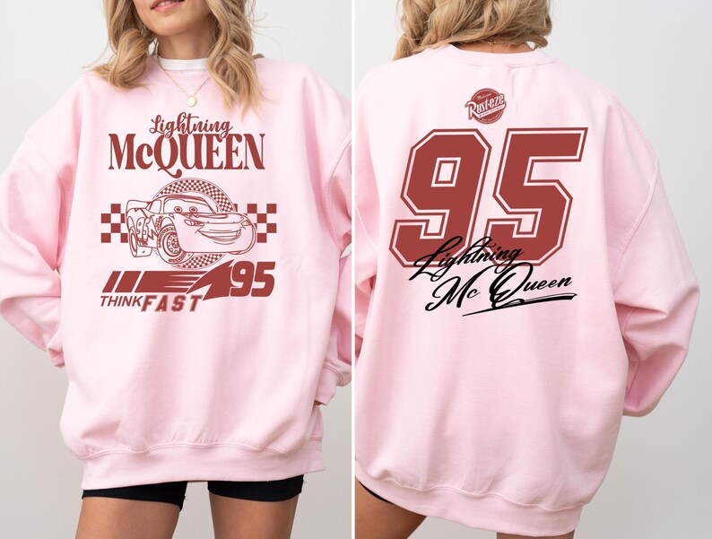 May include: Pink sweatshirt with a red graphic of Lightning McQueen from the Cars movie. The graphic includes the text "Lightning McQueen", "Think Fast", and "95".