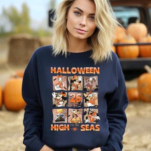 May include: A navy blue sweatshirt with a graphic print of Mickey Mouse and other Disney characters. The text "HALLOWEEN on the HIGH SEAS" is printed on the front of the sweatshirt.