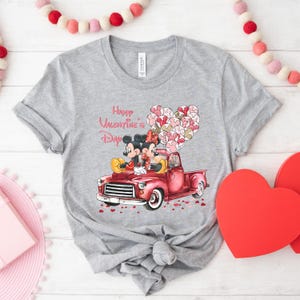 May include: A gray t-shirt with a red truck, Mickey Mouse and Minnie Mouse, and the text "Happy Valentine's Day".