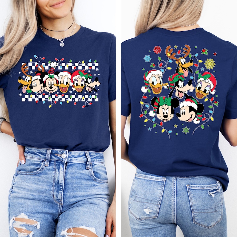 Puede incluir: Una camiseta azul marino con un dise&ntilde;o navide&ntilde;o con Mickey Mouse, Minnie Mouse, Donald Duck, Goofy y Pluto con gorros de Pap&aacute; Noel y rodeados de luces navide&ntilde;as. El dise&ntilde;o est&aacute; en la parte delantera de la camiseta, y la parte trasera de la camiseta presenta un dise&ntilde;o similar con los personajes dispuestos en un c&iacute;rculo.