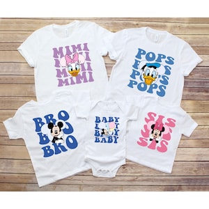 Puede incluir: Camisetas blancas y un body para beb&eacute; con gr&aacute;ficos de personajes de Disney. Las camisetas presentan a Daisy Duck, Donald Duck, Mickey Mouse y Minnie Mouse, con las palabras "MIMI", "POPS", "BRO", "BABY" y "SIS".