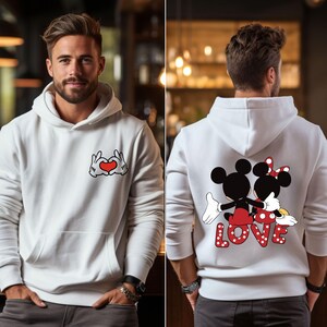 May include: White hoodie with a red heart and hands making a heart shape on the front and a graphic of Mickey Mouse and Minnie Mouse with the word "LOVE" on the back.