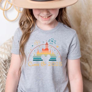 May include: A gray t-shirt with a retro-style illustration of Cinderella's castle with fireworks and the text "Class of 2025".