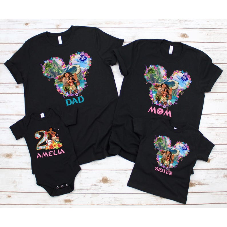 May include: Black family matching t-shirts and a onesie. The shirts feature a colorful graphic in the shape of Mickey Mouse ears with a tropical scene and the words "Dad", "Mom", and "Sister". The onesie says "Amelia" and "2".