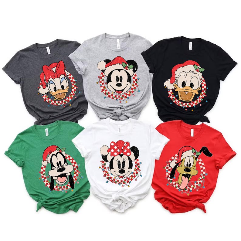 May include: Six different Christmas themed t-shirts featuring various Disney characters. The shirts are in different colors, including red, green, white, black, and gray. Each shirt features a different Disney character wearing a Santa hat and surrounded by a wreath of Christmas lights.