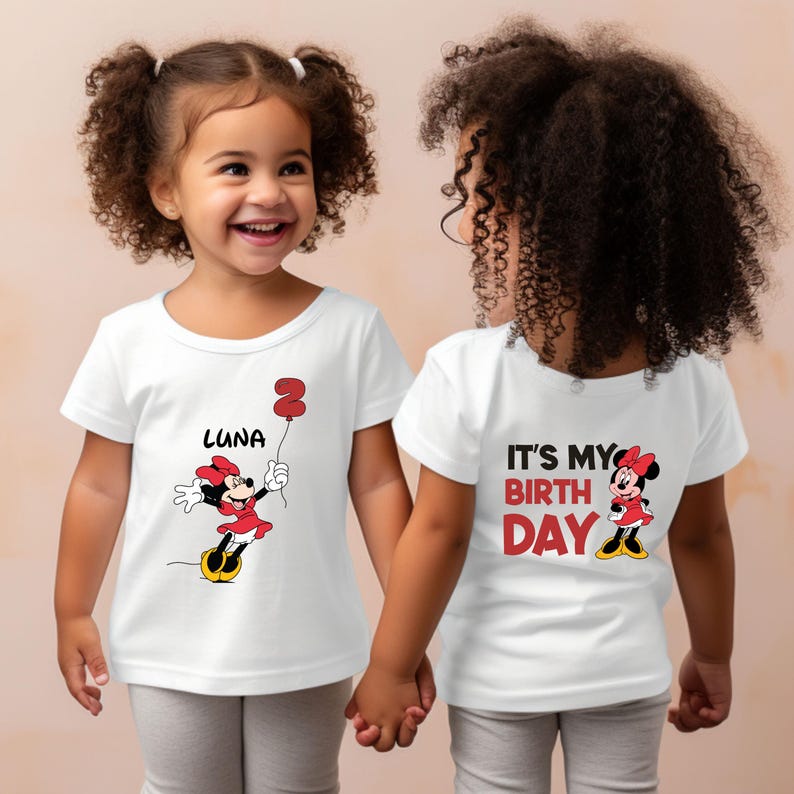Puede incluir: Dos camisetas blancas con un dise&ntilde;o de Minnie Mouse. Una camiseta dice "Es mi cumplea&ntilde;os" y la otra dice "Luna" con un globo n&uacute;mero 2.
