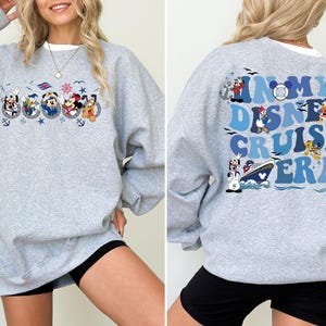 May include: Gray sweatshirt with a blue and white graphic of Disney characters and the text "In My Disney Cruise Era".