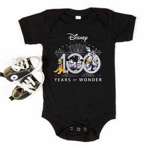 May include: Black baby onesie with a white graphic of Mickey Mouse, Donald Duck, Goofy, and Pluto celebrating Disney's 100th anniversary. The graphic includes the text "Disney 100 Years of Wonder".