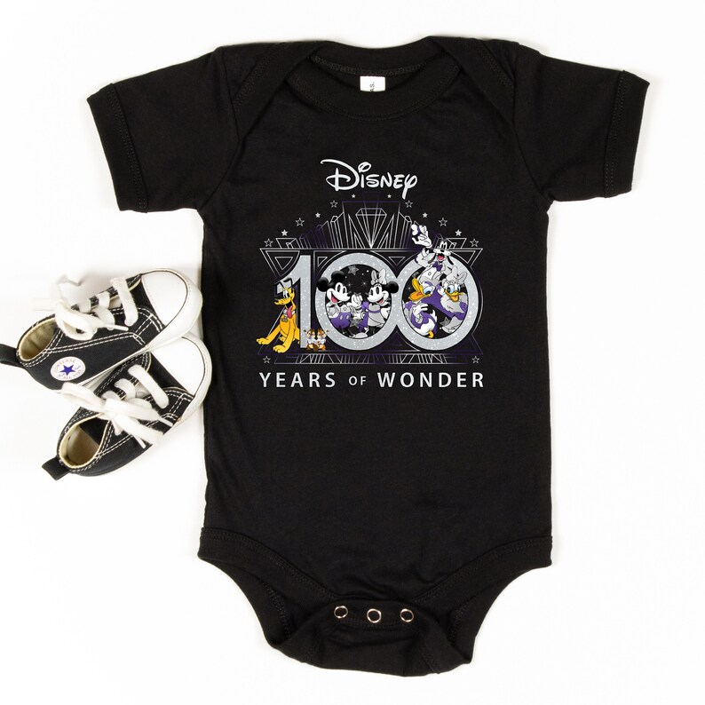 May include: Black baby onesie with a white graphic of Mickey Mouse, Donald Duck, Goofy, and Pluto celebrating Disney's 100th anniversary. The graphic includes the text "Disney 100 Years of Wonder".