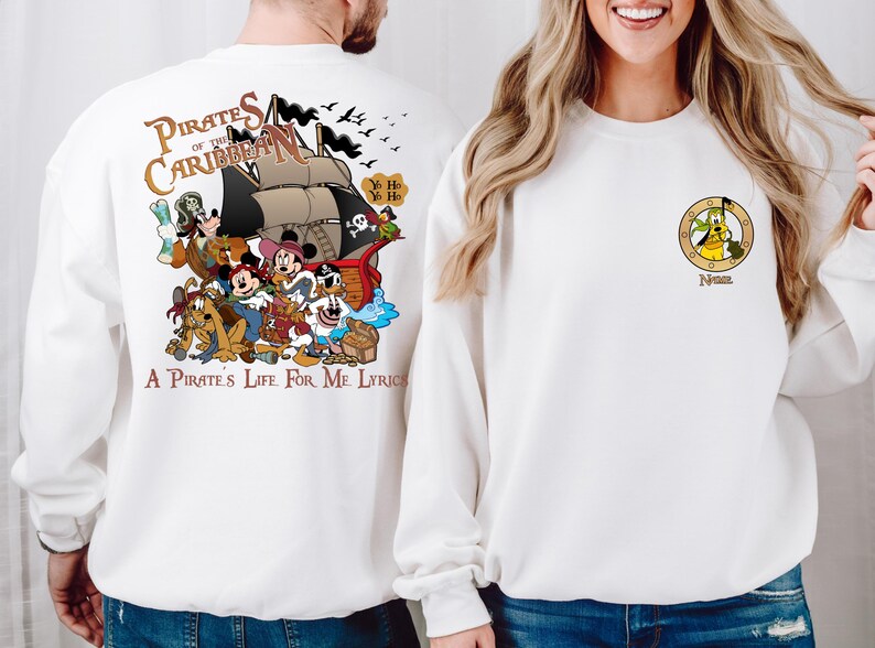 May include: White sweatshirt with a colorful cartoon image of Mickey Mouse and friends on a pirate ship. The text "Pirates of the Caribbean" and "A Pirate's Life For Me Lyrics" are printed on the sweatshirt.