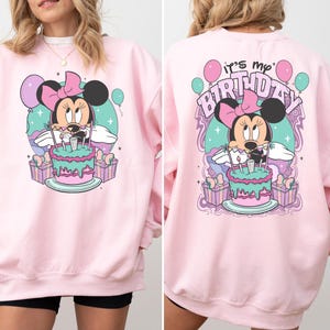 May include: Pink sweatshirt with a graphic of Minnie Mouse holding a birthday cake and the text "It's my Birthday" on the back.
