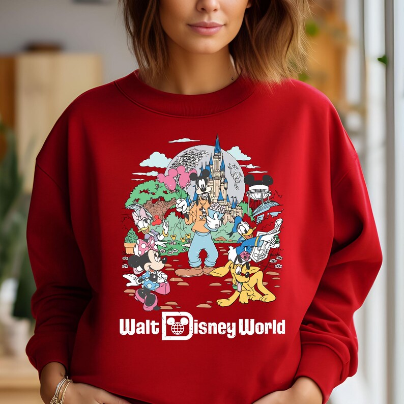 May include: Red sweatshirt with a colorful graphic of Mickey Mouse and other Disney characters in front of Cinderella's Castle. The text "Walt Disney World" is printed below the graphic.