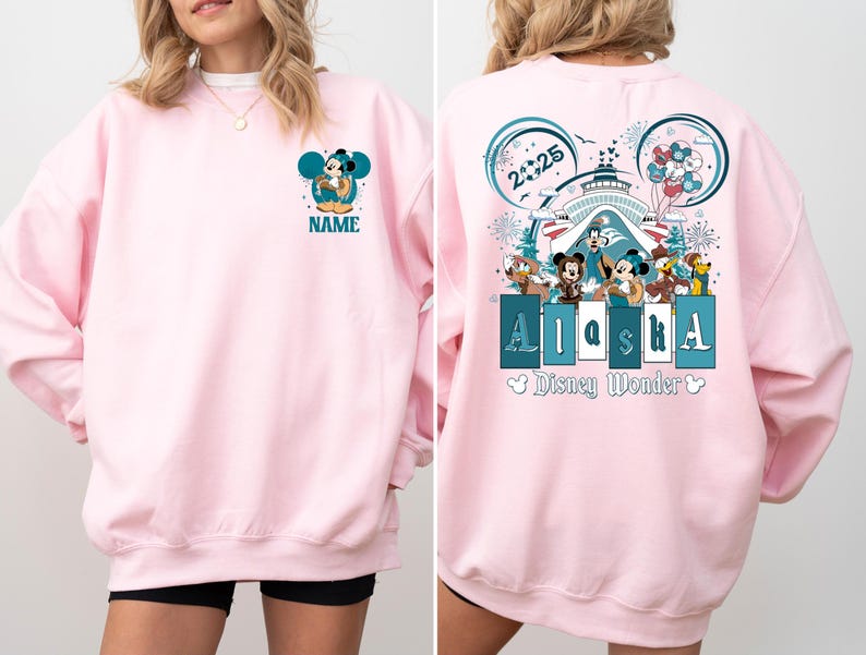 May include: Pink sweatshirt with a Mickey Mouse design on the front and a Mickey Mouse design with the text "Alaska" and "Disney Wonder" on the back.