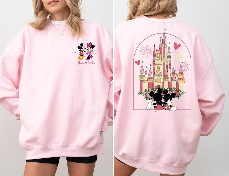 K&ouml;nnte beinhalten: Rosafarbener Pullover mit einem Mickey Mouse und Minnie Mouse Motiv auf der Vorderseite und einem Motiv von Schloss Aschenputtel mit Mickey Mouse und Minnie Mouse auf der R&uuml;ckseite. Der Text "Jack & Emily" ist unter dem Mickey Mouse und Minnie Mouse Motiv gedruckt.