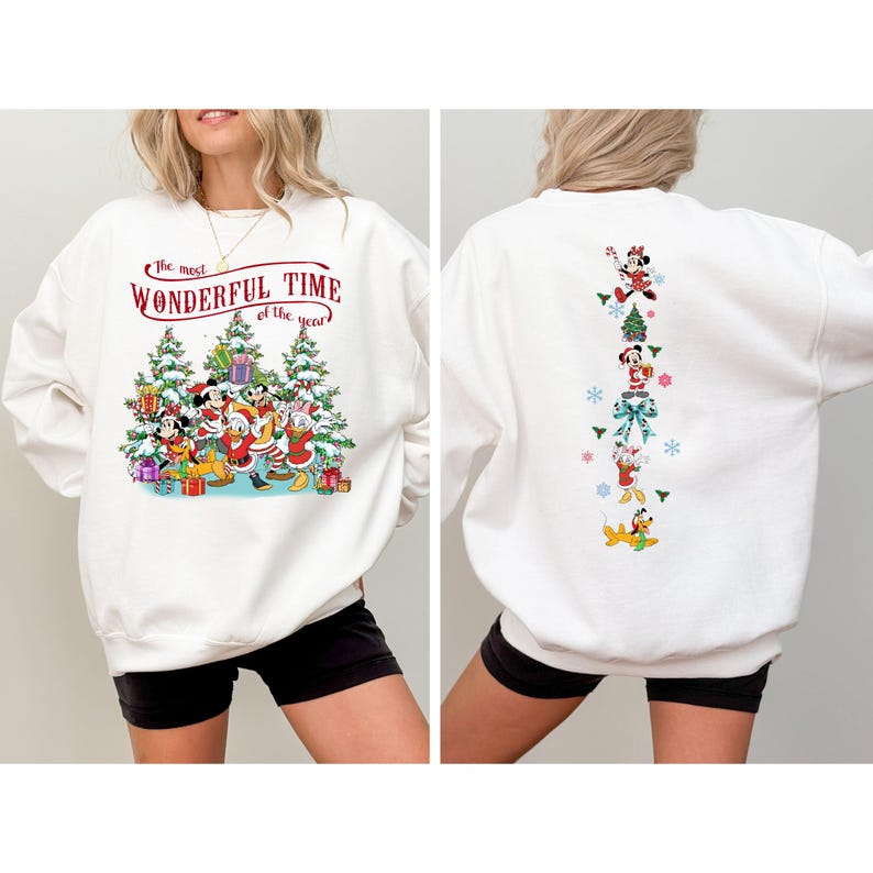 Puede incluir: Sudadera blanca con un dise&ntilde;o festivo de Disney. La parte delantera muestra a Mickey, Minnie, Donald y Goofy con &aacute;rboles de Navidad y el texto "The Most Wonderful Time of the Year". La parte trasera tiene una l&iacute;nea vertical de personajes de Disney y copos de nieve.