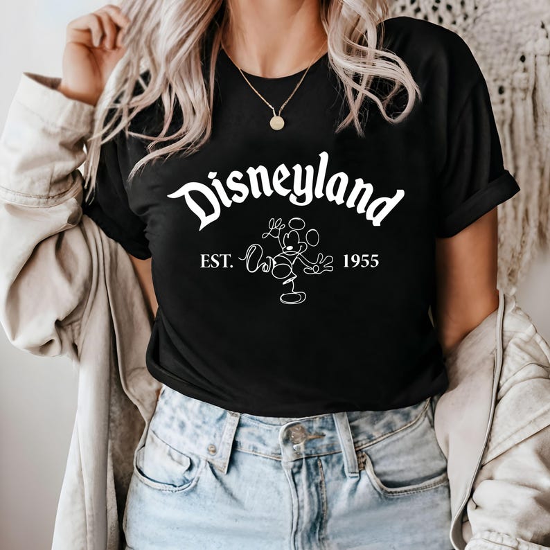 May include: Black t-shirt with white text that reads "Disneyland Est. 1955" and a white outline of Mickey Mouse.