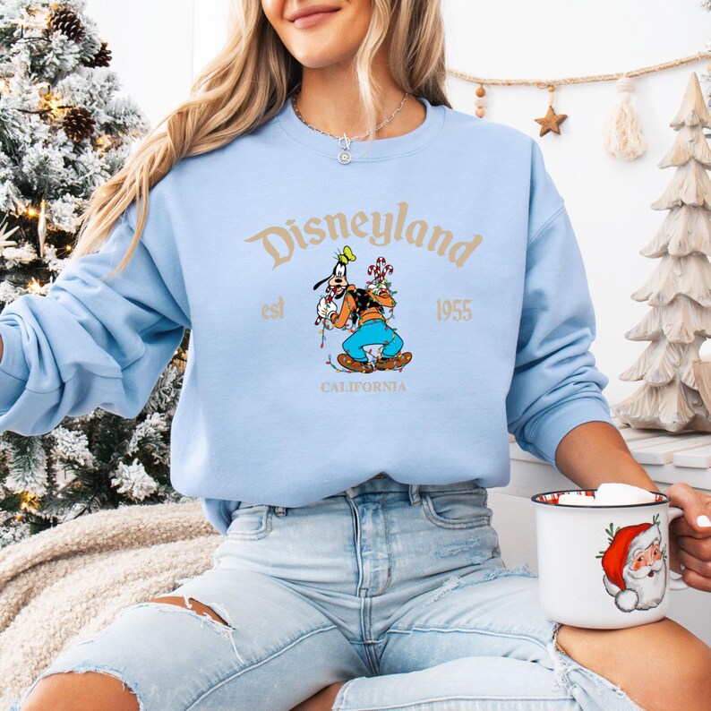 Pu&ograve; includere: Una felpa Disneyland azzurra con una grafica di Pippo e la scritta "Disneyland est 1955 California". La felpa &egrave; realizzata in materiale morbido, perfetta per i fan Disney.