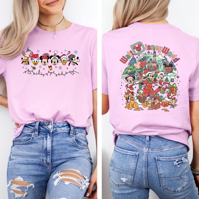 Op de afbeelding: Lichtroze T-shirt met een feestelijk Disney-ontwerp. De voorkant toont Disney-personages in feestelijke kleding met lichtslingers. De achterkant heeft een "Walt Disney World"-afbeelding met personages en cadeaus, perfect voor Disney-fans.