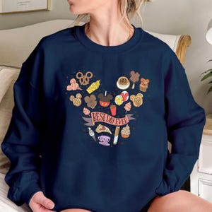 May include: A navy blue sweatshirt with a Mickey Mouse head design made of various Disney park treats and the text "Best Day Ever".
