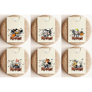 May include: Six cream-colored t-shirts with Halloween-themed graphics. Each shirt features a different cartoon character in a skeleton costume, with the word "Halloween" printed below. The characters include Donald Duck, Mickey Mouse, and Goofy.