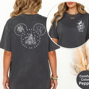 May include: Dark grey t-shirt with a white graphic on the back featuring a castle, fireworks, and the text "THE HAPPIEST PLACE ON EARTH". The front has a small graphic of Mickey Mouse and the word "Daddy".