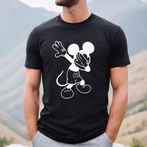 May include: Black t-shirt with a white graphic of Mickey Mouse doing the dab.