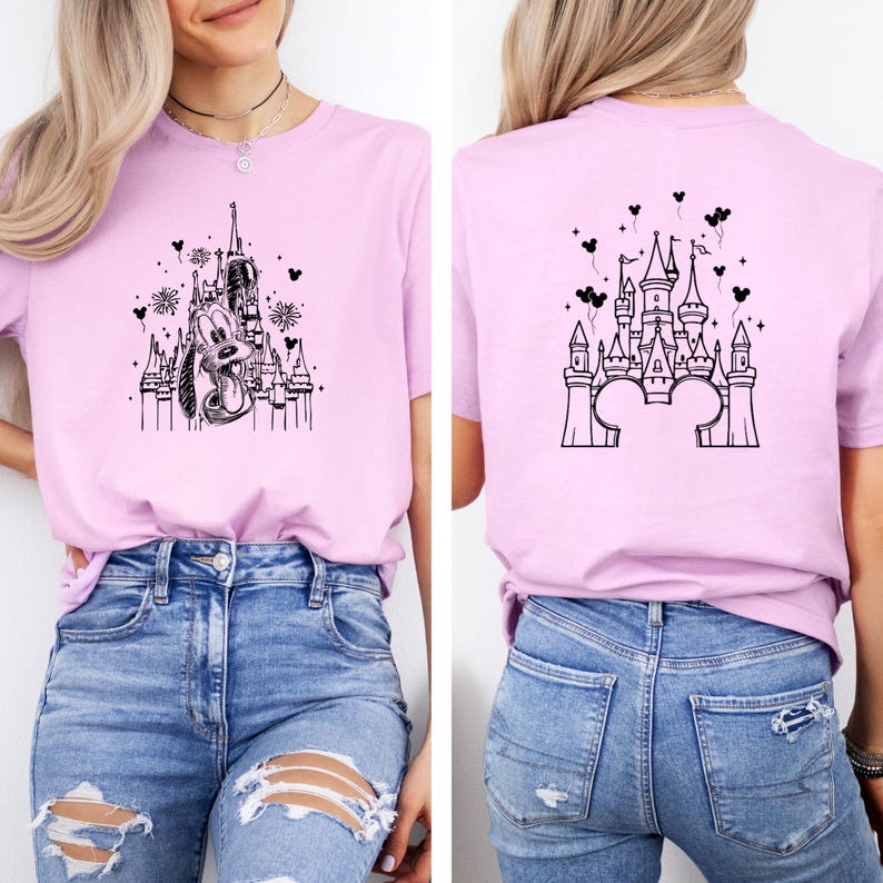 Puede incluir: Camiseta rosa claro con un dise&ntilde;o en blanco y negro de un castillo y Pluto. La parte trasera de la camiseta tambi&eacute;n presenta un dise&ntilde;o de castillo. La camiseta se combina con vaqueros azules.