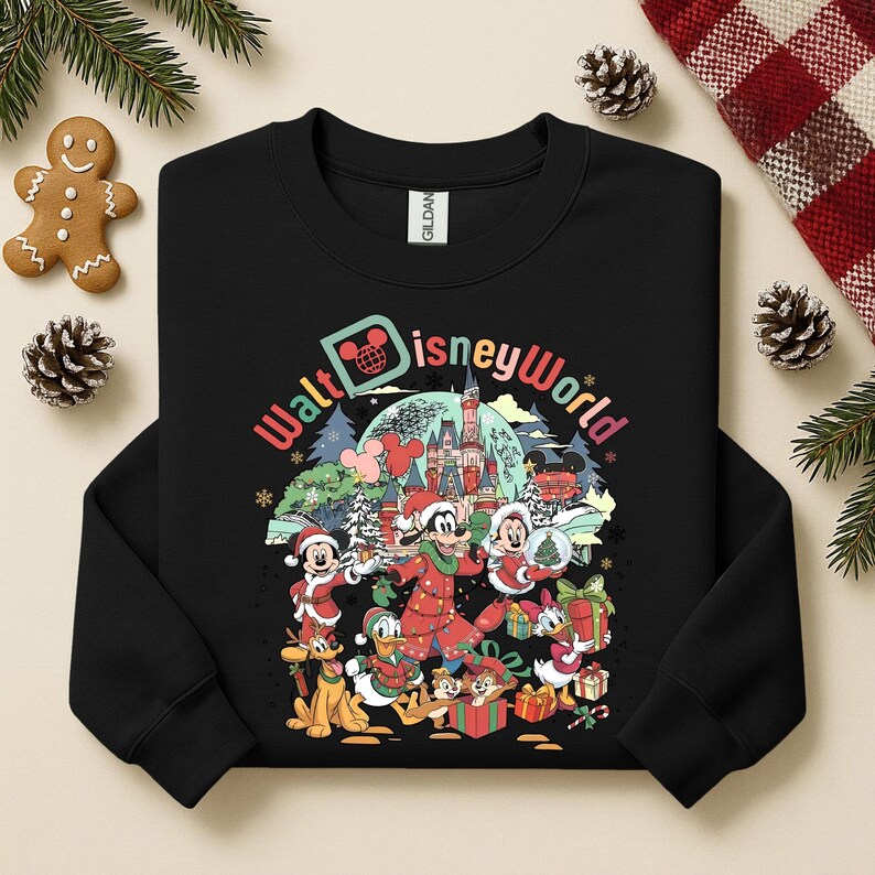 May include: Black sweatshirt featuring a colorful graphic of Disney characters in a winter scene. The design includes Mickey Mouse, Minnie Mouse, Donald Duck, and Goofy, with the words "Walt Disney World" in a festive font. The sweatshirt has a crew neck.