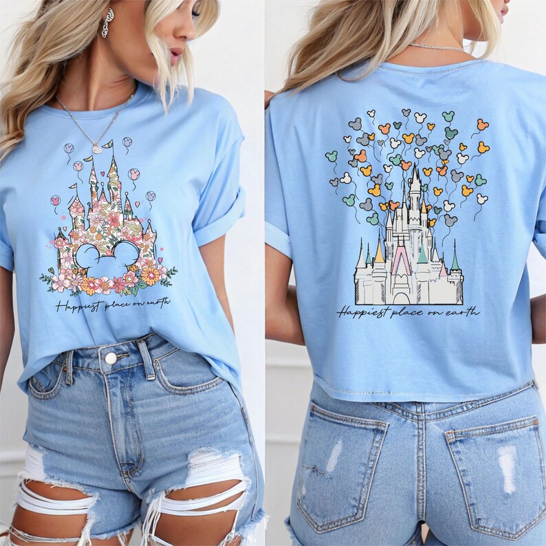 May include: A light blue t-shirt with a graphic of Cinderella's castle with Mickey Mouse ears and the text "Happiest place on earth". The back of the shirt has a graphic of Cinderella's castle with Mickey Mouse balloons.