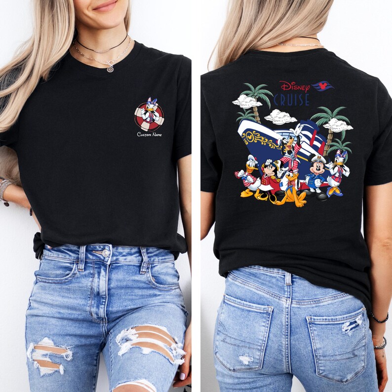 以下が含まれることがあります： 黒のTシャツで、背面にディズニー・クルーズラインのロゴがあります。ロゴには、ミッキーマウス、ドナルドダック、グーフィー、プルートがクルーズ船の前に立っています。Tシャツの前面には、ドナルドダックの漫画が描かれた救命胴衣があります。救命胴衣の下には「カスタムネーム」というテキストがあります。