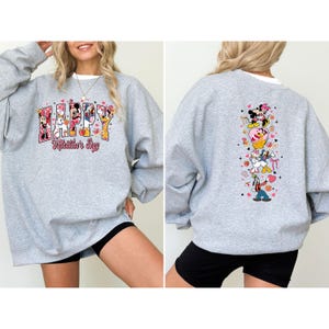 May include: A gray sweatshirt featuring a Valentine's Day design with Disney characters. The front displays "Happy Valentine's Day" with Mickey and Minnie Mouse, Donald Duck, and Goofy. The back has a vertical design with the same characters.