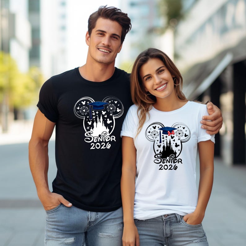Puede incluir: Camisetas negras y blancas con un dise&ntilde;o tem&aacute;tico de graduaci&oacute;n. El dise&ntilde;o presenta una silueta de castillo, un birrete y el texto "Senior 2026". Las camisetas son usadas por un hombre y una mujer.