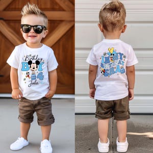 K&ouml;nnte beinhalten: Wei&szlig;es T-Shirt mit einem blauen und gelben Mickey Mouse Geburtstagsdesign. Die Vorderseite des Shirts sagt "Birthday Boy" mit einer Nummer 4 und dem Namen "John". Die R&uuml;ckseite des Shirts sagt "In My Birthday Era" mit einem Mickey Mouse Design.