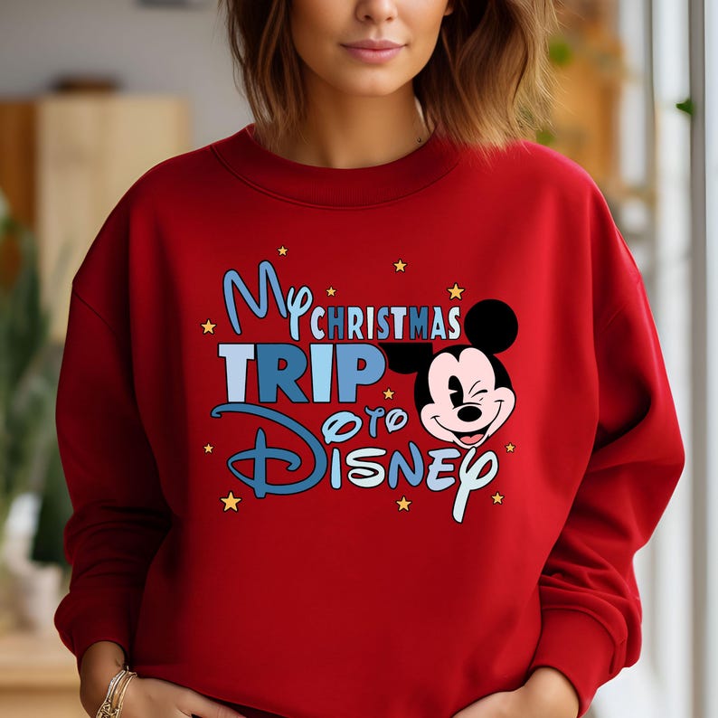 Puede incluir: Sudadera roja con un gr&aacute;fico azul y blanco que dice "My Christmas Trip to Disney" con una imagen de dibujos animados de Mickey Mouse.