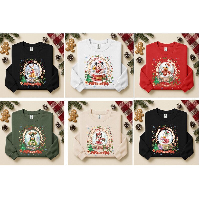 Pode incluir: Seis camisolas de gola redonda em preto, branco, vermelho, verde, bege e preto. Cada uma apresenta um design de globo de neve com personagens da Disney. Mickey, Minnie, Donald e Pluto s&atilde;o retratados em cenas festivas, com o ano de 2025.