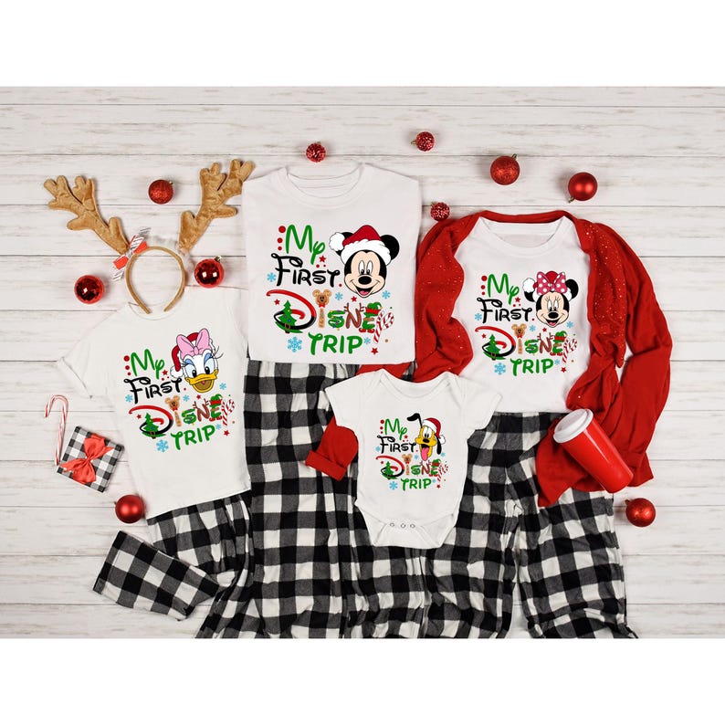 May include: A family of four wearing matching white shirts with a Christmas-themed "My First Disney Trip" design. The shirts feature different Disney characters, including Mickey Mouse, Minnie Mouse, Donald Duck, and Pluto. The family is wearing matching black and white plaid pants.
