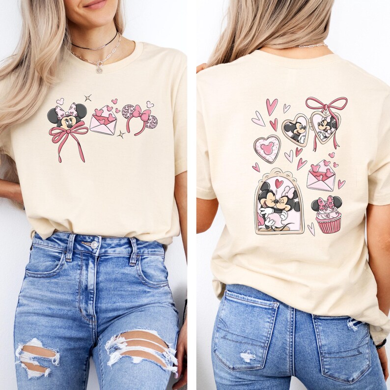 May include: Cream-colored t-shirt featuring a Minnie Mouse design with pink accents. The front displays Minnie with a bow, hearts, and a headband. The back showcases Minnie in heart-shaped frames and a cupcake.