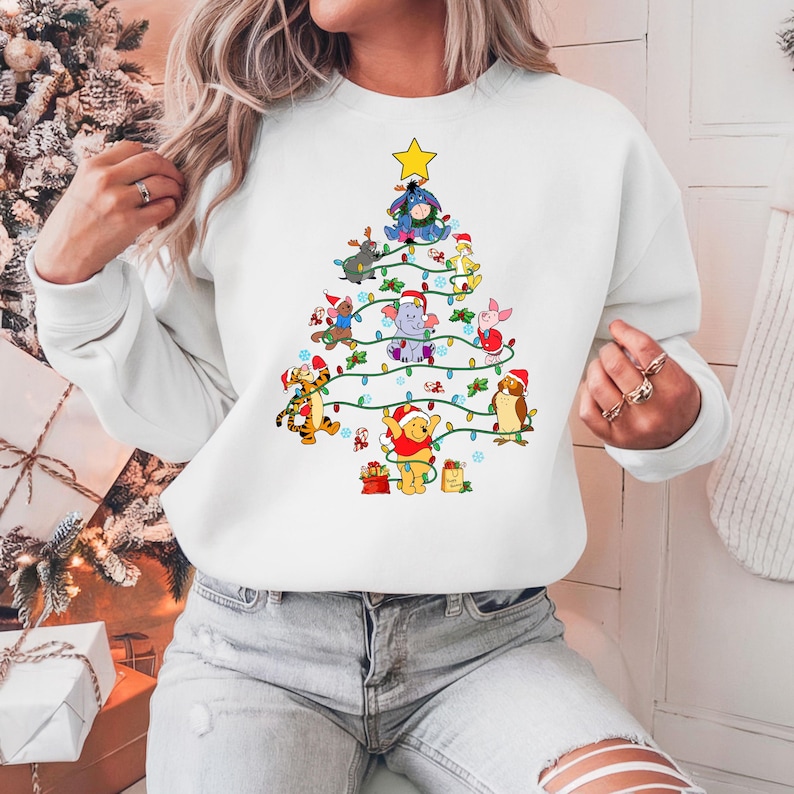 Pu&ograve; includere: Felpa bianca con un design ad albero di Natale composto da personaggi dei cartoni animati, tra cui Winnie the Pooh, Tigro e Pimpi. L'albero &egrave; decorato con luci e una stella, perfetta per le festivit&agrave;.