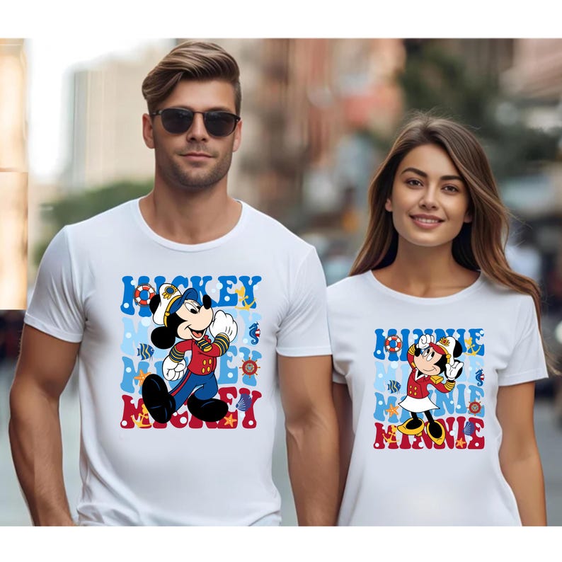 May include: White t-shirts with a nautical theme featuring Mickey Mouse and Minnie Mouse in sailor outfits. The shirts have blue and red accents and the text "Mickey Mouse" and "Minnie Mouse" printed on them.