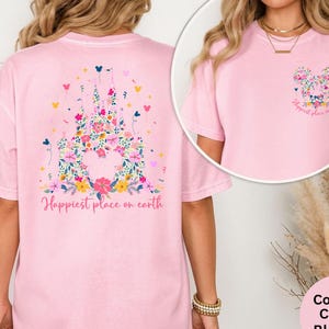May include: A light pink t-shirt featuring a floral castle design on the back and a floral Mickey Mouse head on the front. The text "Happiest place on earth" is printed on the front and back of the shirt. The shirt is made of a soft, comfortable material.