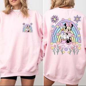 May include: Pink sweatshirt with a rainbow and Mickey Mouse and Minnie Mouse graphic on the back. The front of the sweatshirt has a smaller version of the graphic.