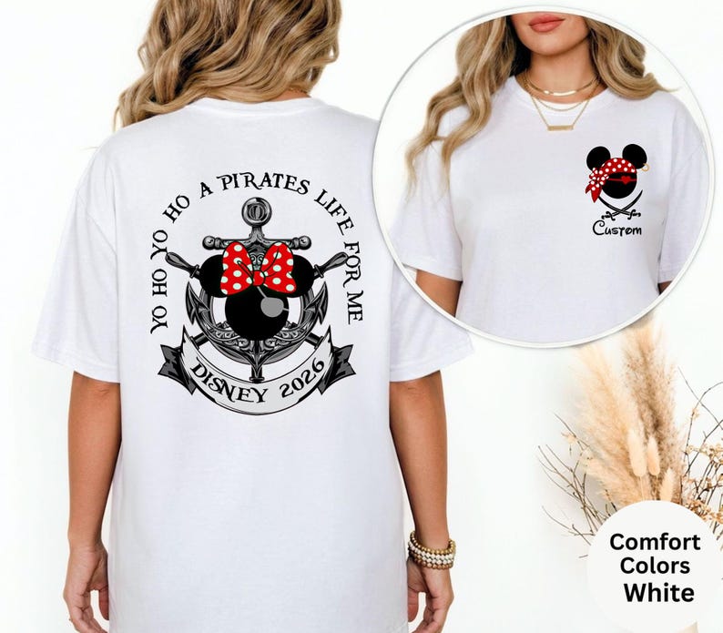 May include: White t-shirt with a pirate-themed design. The back features an anchor, Minnie Mouse ears with a red polka dot bow, and the text "Yo Ho Ho A Pirates Life For Me Disney 2026". The front has a Minnie Mouse pirate design and the word "Custom".