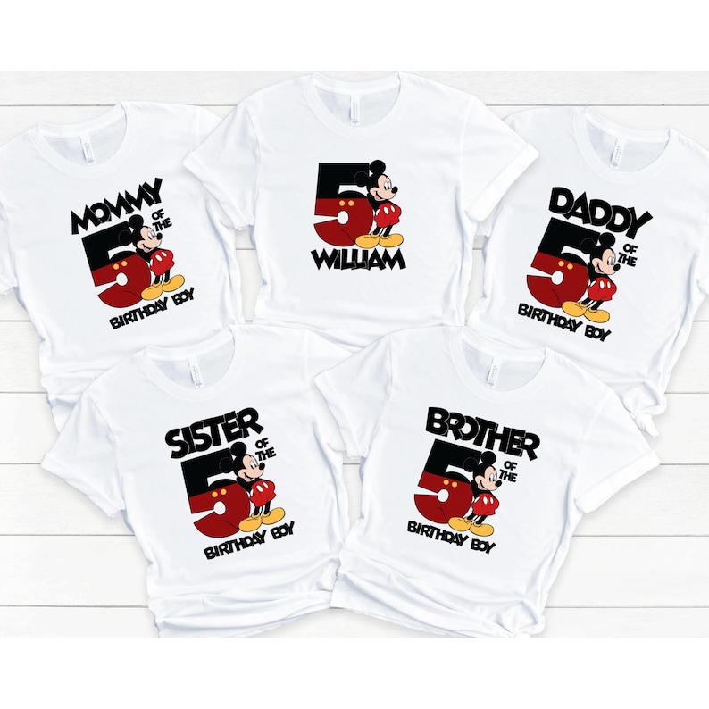 Puede incluir: Camisetas blancas con un gr&aacute;fico de Mickey Mouse. Cada camiseta presenta un gran n&uacute;mero 5 en rojo y negro, con Mickey Mouse. El texto incluye "Mommy", "Daddy", "Sister", "Brother", "William" y "Birthday Boy".