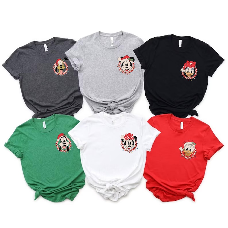 May include: Six different t-shirts with a variety of Disney characters wearing Santa hats. The shirts are in different colors, including red, green, white, black, and gray.