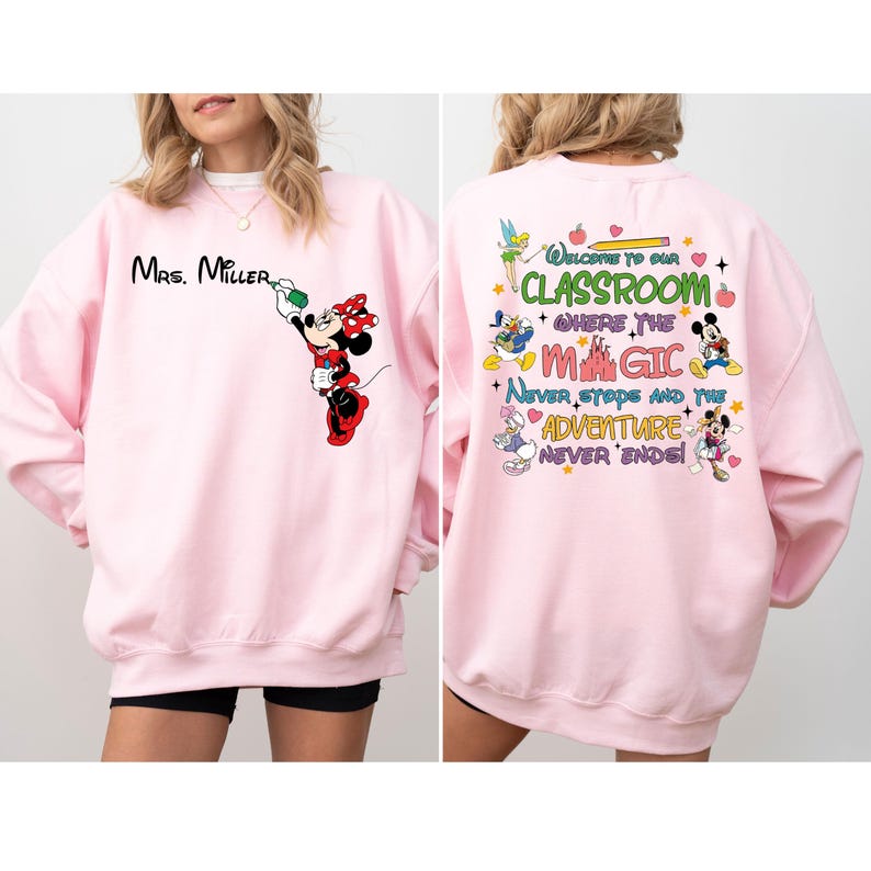 May include: Pink sweatshirt with a Mickey Mouse design on the front and a Disney-themed design on the back. The front design features Mickey Mouse painting the words 'Mrs. Miller.' The back design features a colorful castle, Mickey Mouse, Minnie Mouse, Donald Duck, Goofy, and Tinkerbell. The text on the back reads 'Welcome to our Classroom where the Magic Never Stops and the Adventure Never Ends!'