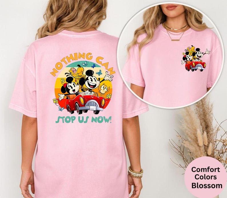 Pode incluir: T-shirt rosa claro com um desenho do Mickey e da Minnie Mouse num carro vermelho, com o texto "Nothing Can Stop Us Now!" nas costas. Uma vers&atilde;o mais pequena do desenho est&aacute; na frente. A t-shirt &eacute; um Comfort Colors Blossom.